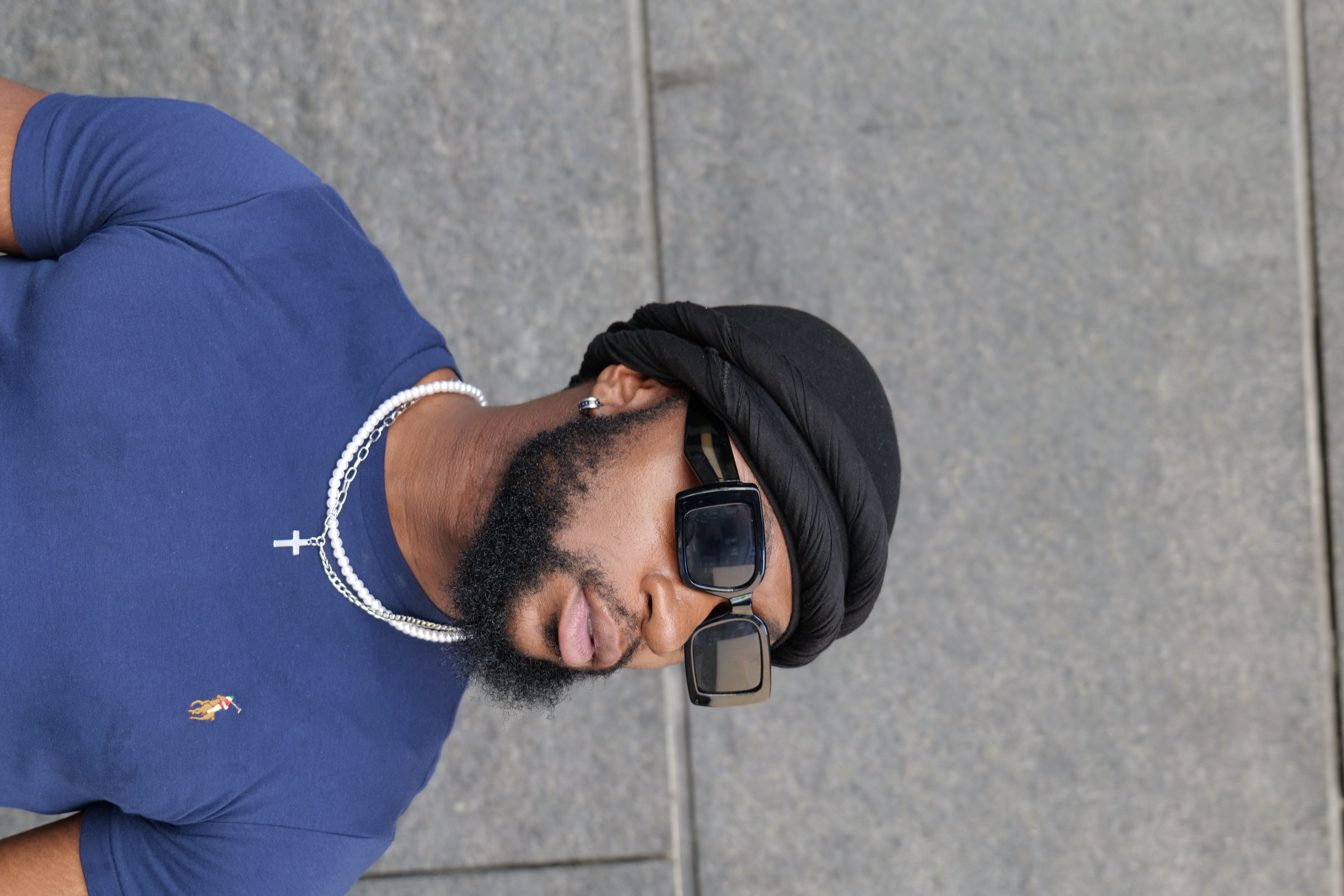 Portrait of Sweepy Dee wearing sunglasses and a black headwrap